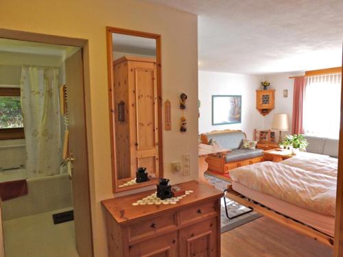 um quarto com uma cama e uma casa de banho com um espelho. em Pra d'Sura 104 em Maloja