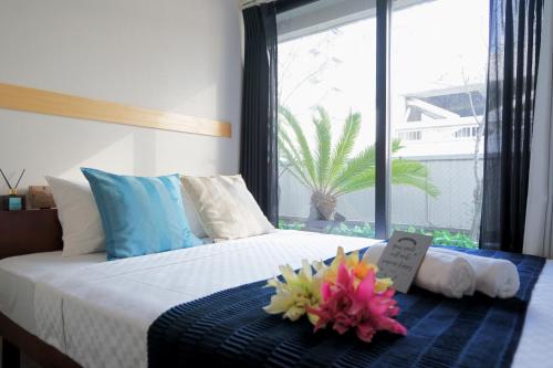 a bedroom with a bed with two flowers on it at Feel Osaka Yu in Osaka