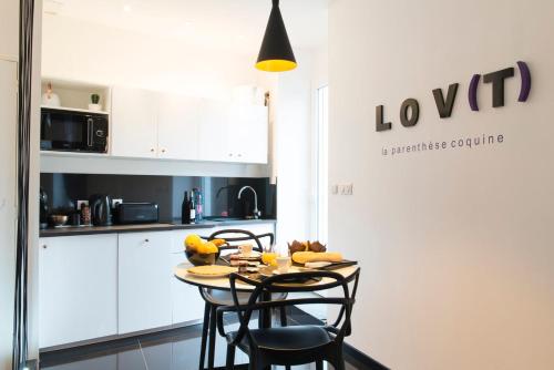 uma cozinha com mesa e cadeiras num quarto em Le Lovt - LOVE ROOM NANTES em Nantes