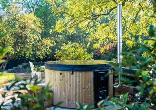 a hot tub in the middle of a garden at Stunning Victorian Converted Mill, 3 BDR Retreat in Cheltenham