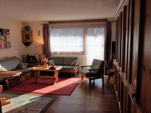 a living room with a couch and a table at Pra d'Sura 104 in Maloja
