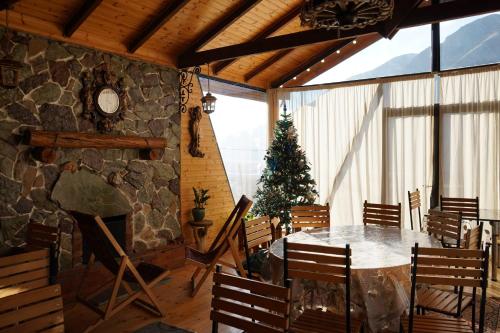 Panorama Cottages في كازباجي: غرفة طعام مع طاولة وشجرة عيد الميلاد