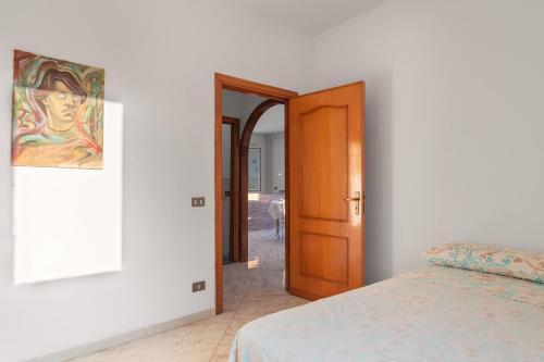 a bedroom with a bed and a wooden door at Appartamento in Villa Marlory in Monreale