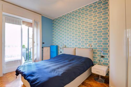 a bedroom with a blue accent wall and a bed at Design apartment in the design district of Milan in Milan