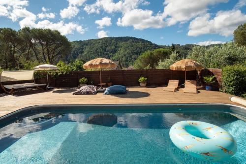 a swimming pool with umbrellas on a patio with at L'appart - Les Lodges de Praly in Les Ollières-sur-Eyrieux