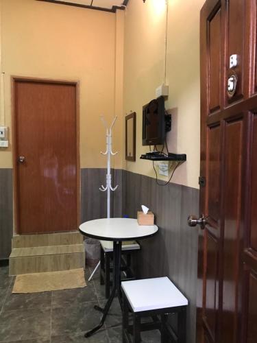 a room with a table and a tv and a door at Baan Aomsin in Chiang Khan