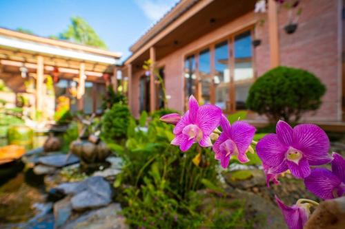 un grupo de flores púrpuras frente a una casa en Sakura Mura Retreat and Wellness, en Phu Quoc