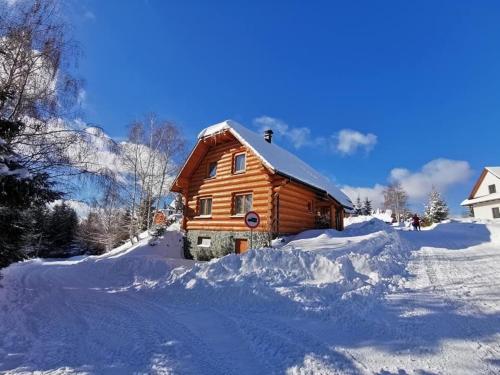 Cabaña de madera con nieve en el suelo en Zrub na Briežku, en Krahule