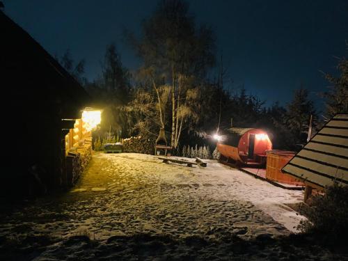 a snow covered street at night with a train at Zrub na Briežku in Krahule