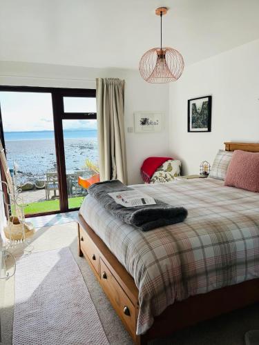 una camera da letto con un letto con vista sull'oceano di Relaxing cottage with spectacular view, Sauna and Spa Pool a Kircubbin