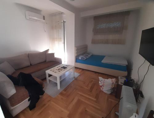 uma pequena sala de estar com um sofá e uma mesa em Apartment Luka em Podgorica