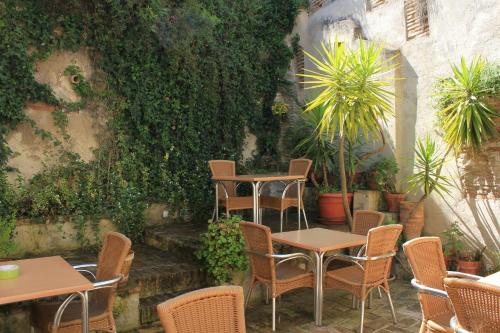 a patio with tables and chairs and plants at Hotel Boutique Puerta de las Granadas in Granada