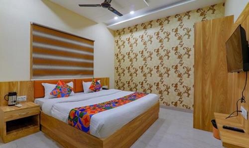 een slaapkamer met een bed en een televisie. bij FabHotel Super 3 Premium in Varanasi
