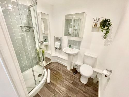 La salle de bains est pourvue de toilettes, d'un lavabo et d'une douche. dans l'établissement A Cozy Hideaway with Balcony - Close to Beach, à Bournemouth