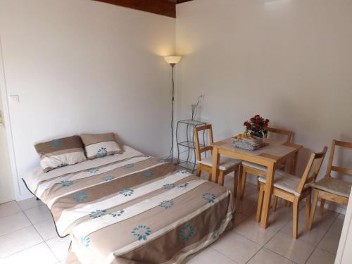 um quarto com uma cama e uma mesa com cadeiras em Sans Souci em Cahuzac