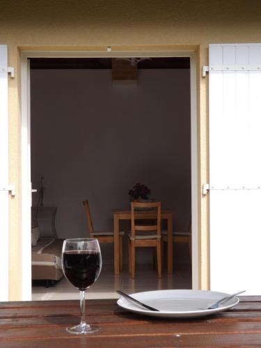a glass of wine sitting on a wooden table with a tableablish at Sans Souci in Cahuzac