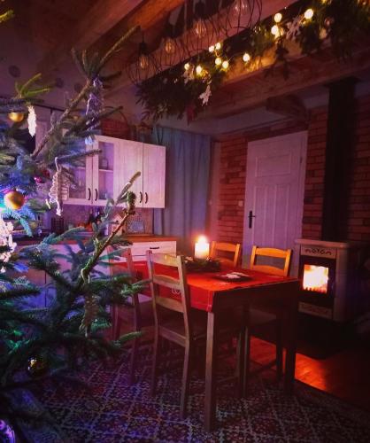 a dining room with a table and a christmas tree at Dom Malarki in Mirosławiec