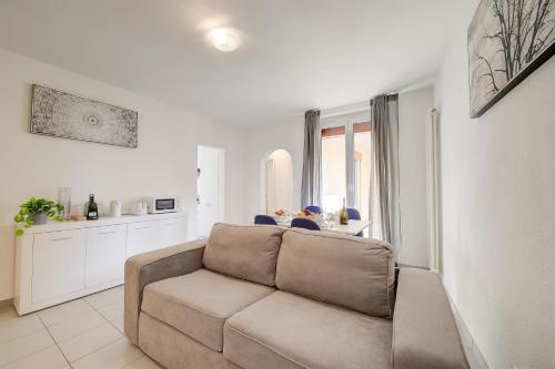 ein Wohnzimmer mit einem Sofa und einer Küche in der Unterkunft Casa Glicine in Lugano