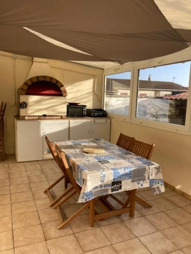 - une table et des chaises dans une cuisine avec une tente dans l'établissement Villa de la Prée, à Saint-Laurent-de-la-Prée