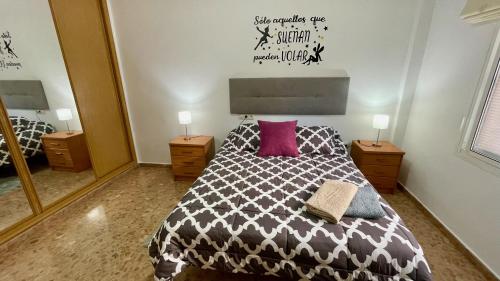 1 dormitorio con 1 cama con edredón blanco y negro en Palacio de Ferias apartamento, en Málaga