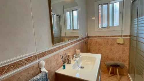 y baño con lavabo y espejo. en Palacio de Ferias apartamento, en Málaga