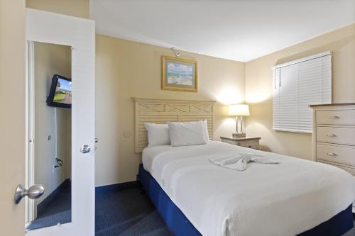 - une chambre avec un grand lit blanc et une fenêtre dans l'établissement 2BR Beachfront Condo w Pools - Atlantica Towers Condo, à Myrtle Beach