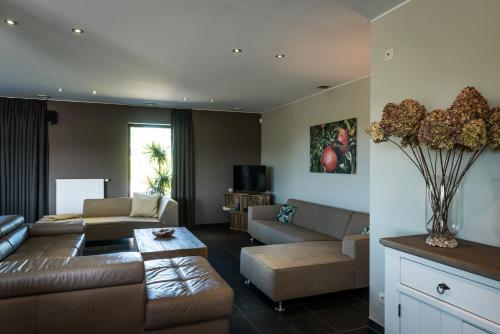 - un salon avec un canapé et une table dans l'établissement Vakantiehoeve Berckelaer, à Saint-Gilles-Waes