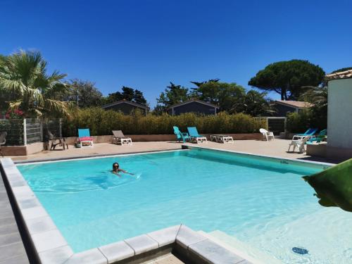 a person swimming in a swimming pool at Camping Hameau Des Cannisses in Gruissan