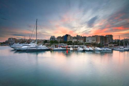 a group of boats docked in a harbor at sunset at Blue Seaview Suites in Piraeus