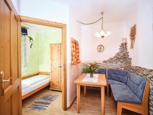 a living room with a blue couch and a table at Zwergerlhof in Loich