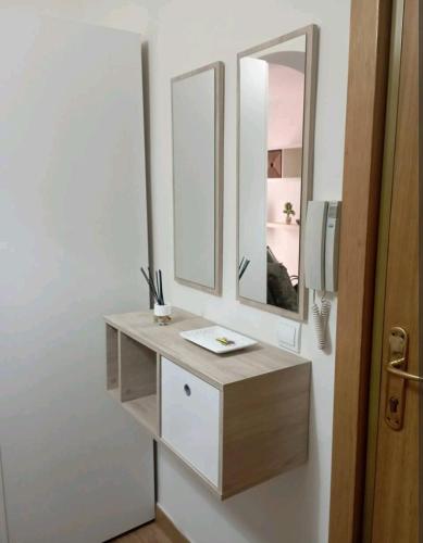 a bathroom with a sink and two mirrors at Apartamento parque sur de Hellín in Hellín