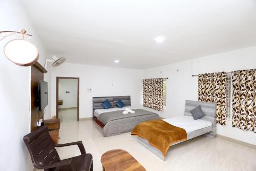 a bedroom with a bed and a tv in it at Deekay Villa Yelagiri By Lexstays in Yelagiri