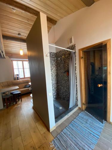 una gran ducha de cristal en una sala de estar con una habitación en Dzirnavas Pirtsmāja, en Cesvaine