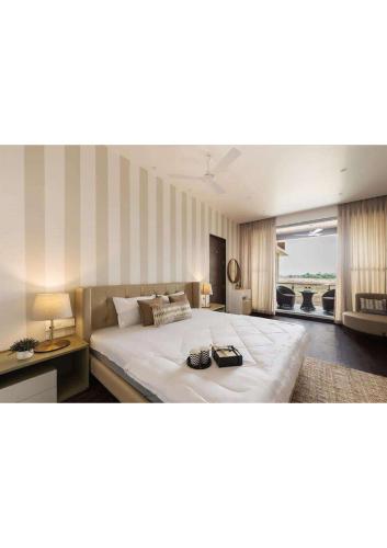 Un dormitorio con una gran cama blanca y una ventana en Grey villa pure veg 4BHK, en Lonavala