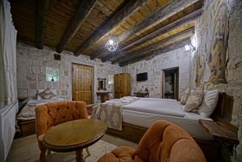 a bedroom with a bed and a table and chairs at Risus Cave Suites in Goreme
