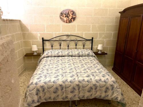 オーリアにあるLa Corte del Reのベッドルーム1室(ベッド1台、ランプ2つ、壁付)