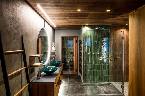 y baño con ducha y 2 lavabos verdes. en Luxury Chalet Vilaiet en Ortisei