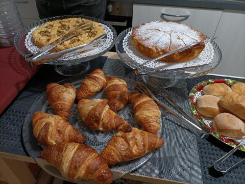 un montón de croissants y otros pasteles en una mesa en La Rosa Dei Venti en Finale Ligure