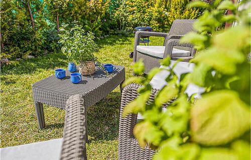 a patio table and chairs with blue cups on it at Awesome Home In Ustka With 2 Bedrooms And Wifi in Ustka