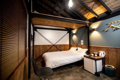 een kamer met een bed, een bureau en een stoel bij リゾートイン西表島 in Iriomote