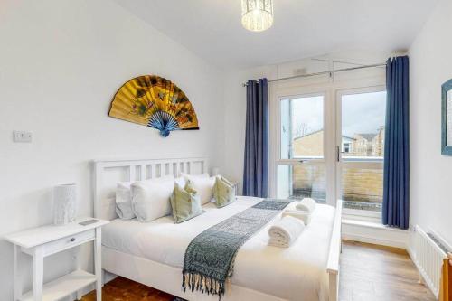 - une chambre blanche avec un lit et une fenêtre dans l'établissement Beautiful 4-bedroom house in Victoria Park, à Londres