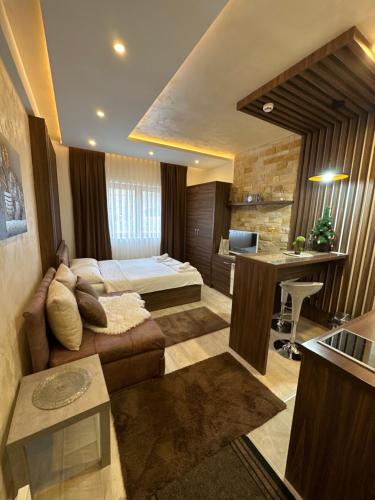 uma sala de estar com um sofá e uma cama em Apartmani Fashion -Milmari Resort em Kopaonik
