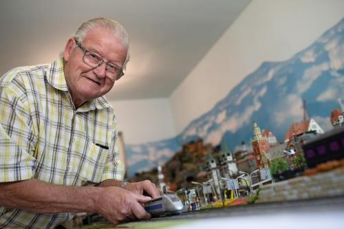 an older man is playing with a toy train at Zwergerlhof in Loich