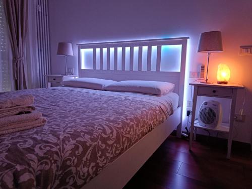 Un dormitorio con una cama grande y una mesa con una lámpara. en Airport Suites in Florence with FREE parking en Florencia