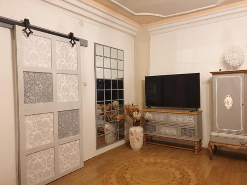 a living room with a flat screen tv and a entertainment center at Stillvolle Designwohnung im historischen Zentrum in Stolberg i. Harz