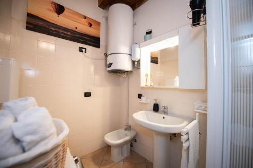 a white bathroom with a sink and a toilet at The Three Moons Apartment in Peschiera del Garda