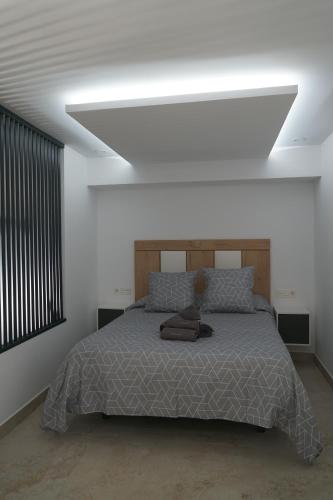 1 dormitorio con 1 cama grande y techo blanco en Apartamento Turistico Hermanos Infantes, en Estepona