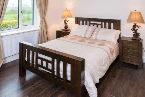 a bedroom with a large bed and two night stands at Island Winds Along The Atlantic Way in Killala
