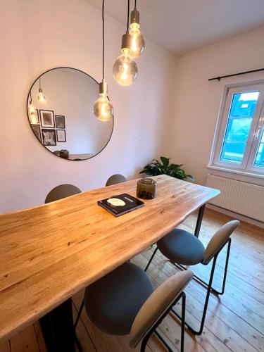a dining room table with chairs and a mirror at Stadtoase Design Wohnung in der Altstadt von Koblenz in Koblenz