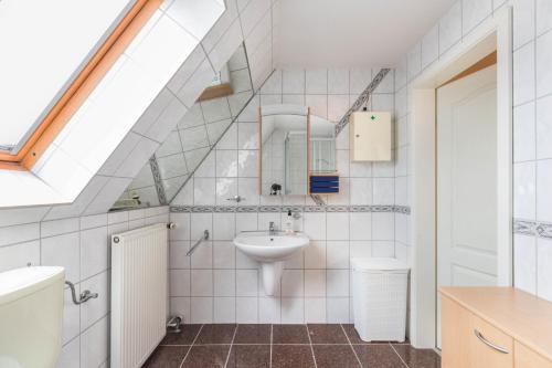 ein Bad mit einem Waschbecken und einem Spiegel in der Unterkunft Haus Liberty 2 in Büsum